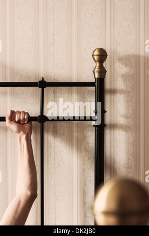 Arm of man holding a firm desperate grip on bed Stock Photo