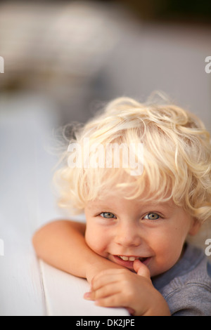 Portrait Of A Smiling Child With Blonde Curly Hair On Examination