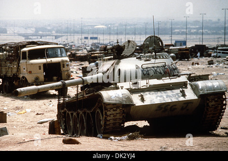 A destroyed Iraqi T-55 main battle tank, painted with graffiti by Coalition troops, lies amidst other destroyed vehicles along Kuwait Highway 8, the route fleeing Iraqi forces took as they retreated from Kuwait during Operation Desert Storm April 18, 1991 in Kuwait. The road is known as the 'highway of death' because of the number of vehicles destroyed by allied forces. Stock Photo