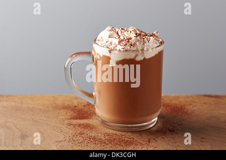 Cup of hot chocolate with whipped cream on wooden table Stock Photo
