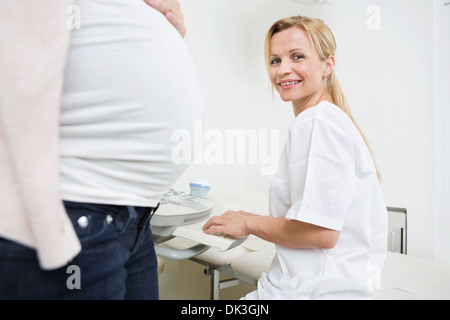 Happy Doctor Using Ultrasound Machine In Clinic Stock Photo