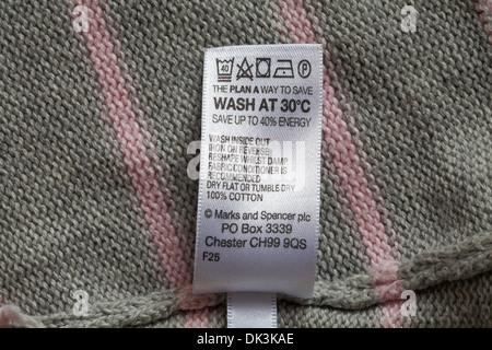 label in Marks & Spencer garment - The Plan A way to save wash at 30 degrees C save up to 40% energy - care washing symbols and instructions Stock Photo