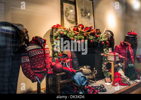 Christmas decorations in shop-window of store selling winter clothes in shopping street in winter Stock Photo