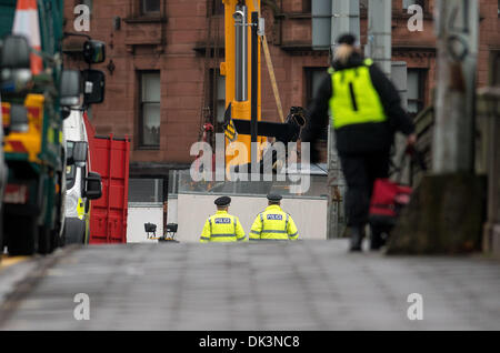 Glasgow, Scotland. 2nd December 2013. Police and Emergency services workers look on as the wreckage of a police helicopter is winched from the collapsed roof of a pub in Glasgow . Mourners lit candles as Scotland remembered those who were killed when a police helicopter plunged through the roof of a Glasgow pub, killing at least nine people, police said. Emergency service workers earlier began attempts to winch the police aircraft back through the roof of The Clutha, where it is feared further corpses may be found under its carcass, further raising the death toll. Credit:  Sam Kovak/Alamy Live Stock Photo