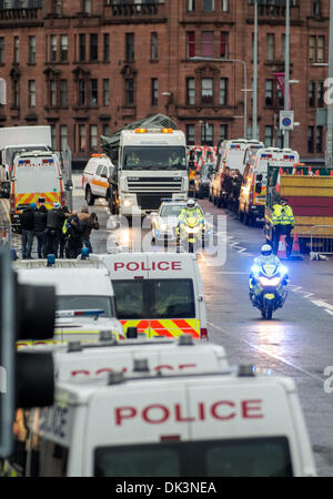 Glasgow, Scotland. 2nd December 2013. Police escort a lorry carrying the police helicopter from the The Clutha bar where it crashed last Friday on December 2, 2013 in Glasgow, Scotland. A ninth body has been recovered in the wreckage of Glasgow's Clutha pub which was destroyed when a police helicopter crashed on to the roof of it on Friday night. Photo by Ross Gilmore Credit:  Sam Kovak/Alamy Live News Stock Photo