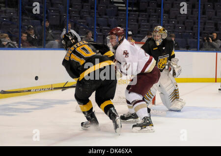 Mar. 25, 2011 - Saint Louis, Missouri, U.S - During the 2011 West Regional playoffs at Scottrade Center in St. Louis, Missouri.  Colorado defenseman Gabe Guentzel (10) tries to relieve some pressure as he wraps the puck around the boards behind his goal while getting pressure from Boston center Pat Mullane (11).  Colorado College controlled the game as they defeated Boston College  Stock Photo