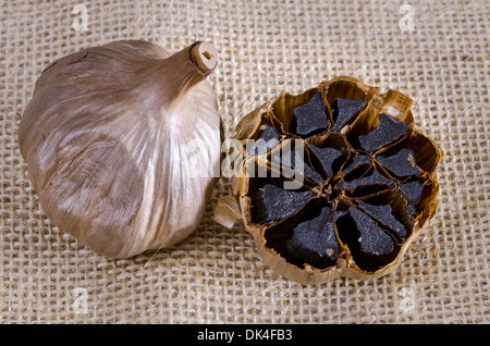 Black garlic bulb with cross section showing black cloves Stock Photo