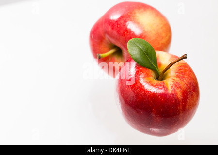 Two red apples on glass surface Stock Photo
