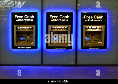 Railway station blue lighting around row of atm cash hole in the wall cashpoint money dispenser machines Kings Cross train station London England UK Stock Photo