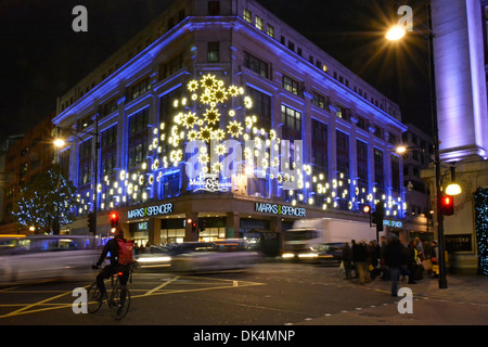 Christmas floodlights Xmas night lights Marks and Spencer store building corner of Oxford Street Baker Street M&S retail shopping business London UK Stock Photo