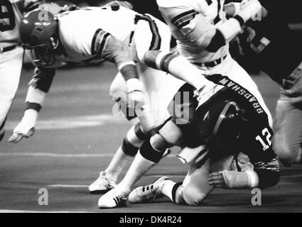 Miami Dolphins linebacker A.J. Duhe (77) leans on Pittsburgh Steelers  quarterback Terry Bradshaw and sacks him during the second quarter of game  in Miami's Orange Bowl Stadium, Thursday, Sept. 11, 1981, Miami