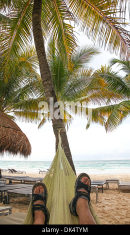 A man relaxing in a hammock on the beach at Riviera Maya Cancun Quintana Roo Yucatan Peninsular Mexico North America Stock Photo