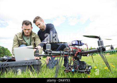 Engineers Using Laptop By UAV Octocopter Stock Photo