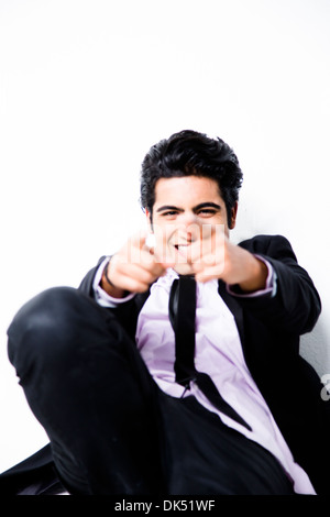 Smiling professional young Indian man pointing confidently Stock Photo