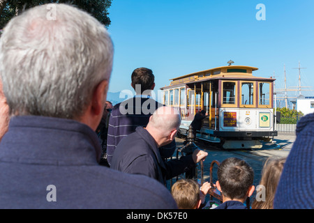 San Francisco Cable Car. Passengers are watching a cable car being turned on a turn table while waiting for boarding. Stock Photo