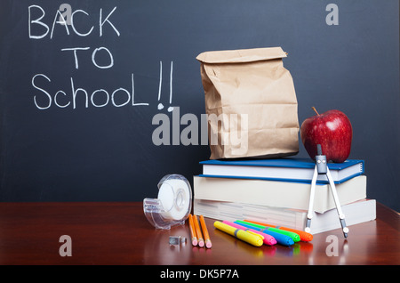 Back to school, school books with apple and paper bag lunch on desk Stock Photo