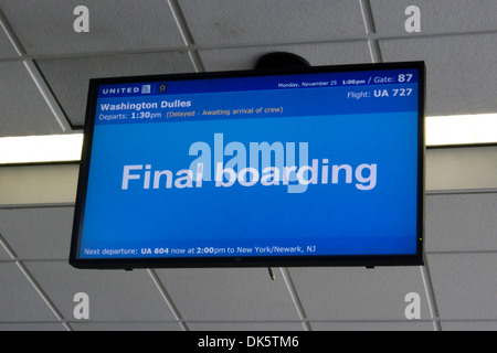 A blue airport terminal flight information display screen showing "Final boarding" for a United flight from Washington Dulles to New York/Newark. Stock Photo