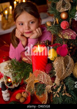 Frankfurt Oder, Germany. 28th Nov, 2013. ILLUSTRATION - An illustrated picture shows seven year old Amy from Boossen near Frankfurt Oder behind a burning candle in an Advent arrangement in Frankfurt Oder, Germany, 28 November 2013. The Advent season with its light sand decorations prepares the mood for Christmas. Photo: Patrick Pleul/dpa/Alamy Live News Stock Photo