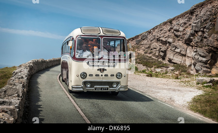 An old UK holiday coach giving a guided tour around the Great Orme coast in Llandudno Wales. Stock Photo