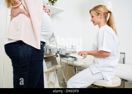 Pregnant Woman With Doctor Using Ultrasound Machine Stock Photo