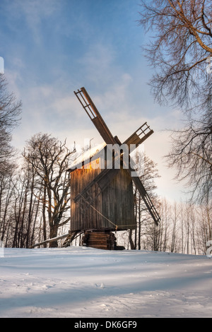 Old timber made windmill in forest at winter day Stock Photo