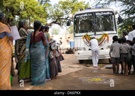Sri Sathya Sai Baba mobile outreach hospital service clinic bus at a rural Indian village school. Andhra Pradesh, India Stock Photo