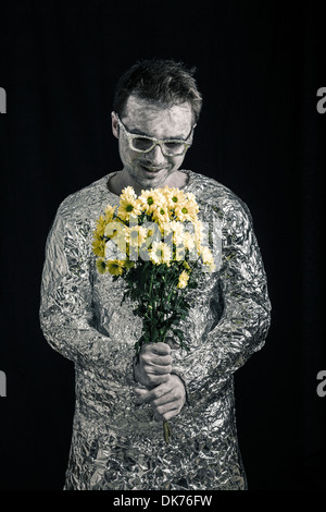 Portrait of satisfied spaceman holding flowers. Stock Photo
