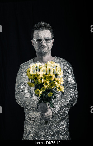Portrait of happy spaceman holding flowers. Stock Photo