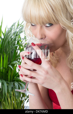 Confident Happy Casual Young Woman Alone Enjoying A Glass Of Red Wine Waiting For the Party To Start Isolated Against A White Background Clipping Path Stock Photo