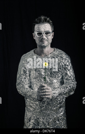 Portrait of happy spaceman holding flower. Stock Photo