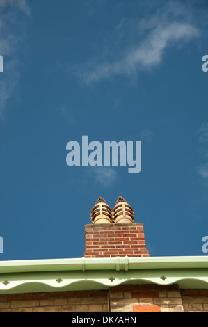 Chimneys on red brick stack, and green guttering.and brick wall Stock Photo