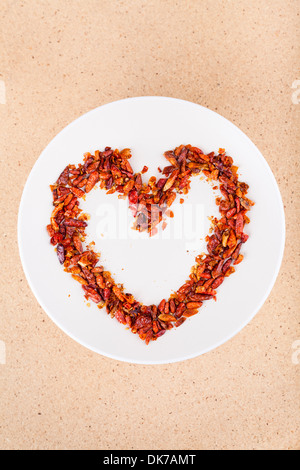 Hot love concept, red chili peppers on plate arranged in heart shape. Hot love concept, red chili peppers on plate arranged in heart shape.