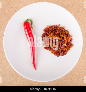 Red chili peppers on plate, over light wooden background. Stock Photo