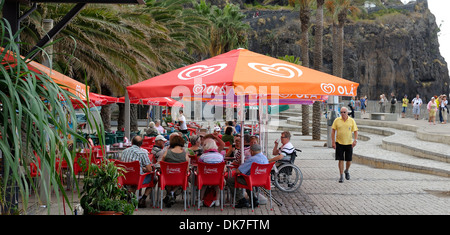Madeira Portugal. Tourists on an island day trip drinking in a sea front cafe in the resort of Ribeira Brava Stock Photo