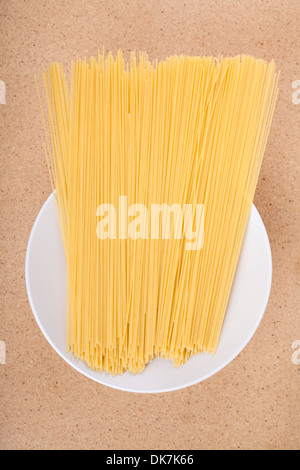 Plate with dried uncooked pasta on the table. Stock Photo