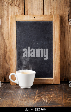 Coffee cup and Vintage slate chalk board on wooden background Stock Photo