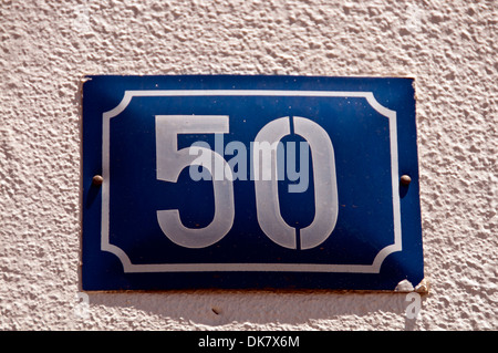 Metal plaque showing house number 50 in white on blue Stock Photo