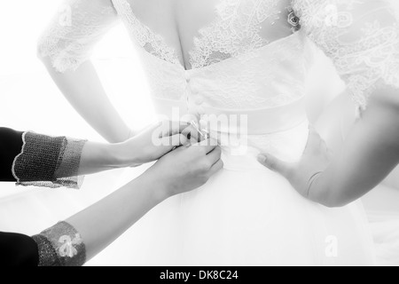 Bride getting dressed and buttoned