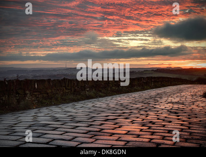 Sunrise over a cobbled road taken in Bolster Moor, Huddersfield, West Yorkshire. Stock Photo