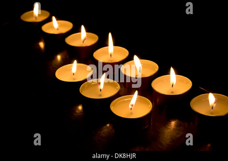 Group of church candles burning in the darkness Stock Photo