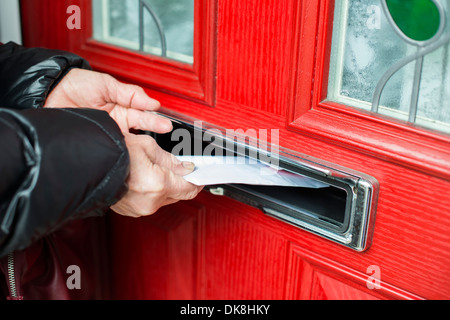 Hand putting Letter in a red mailbox. Stock Photo