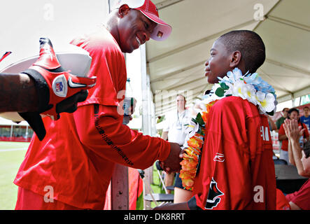 July 30, 2011 - DANIEL WALLACE   |   Times.TP 341686 WALL Bucs 3 (07/30/2011 Tampa) Tampa Bay Buccaneers head coach Raheem Morris talks to 12-year-old Malcolm Williams during Tampa Bay Buccaneers training camp at One Buc Place in Tampa on Saturday. The Bucs and Children's Dream Fund are sending Williams and his family to Hawaii to experience the young boy's dream of surfing and sno Stock Photo