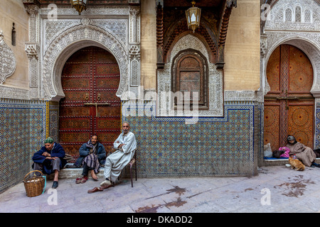 Men sitting outside Mosque Sidi Ahmed Tijani, The Medina, Fez, Morocco Stock Photo