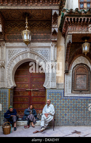 Men sitting outside Mosque Sidi Ahmed Tijani, The Medina, Fez, Morocco Stock Photo