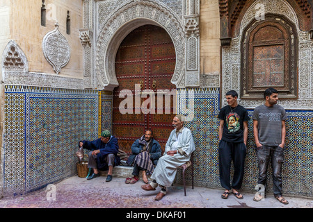 Men sitting outside Mosque Sidi Ahmed Tijani, The Medina, Fez, Morocco Stock Photo