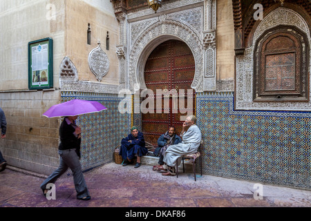 Men sitting outside Mosque Sidi Ahmed Tijani, The Medina, Fez, Morocco Stock Photo