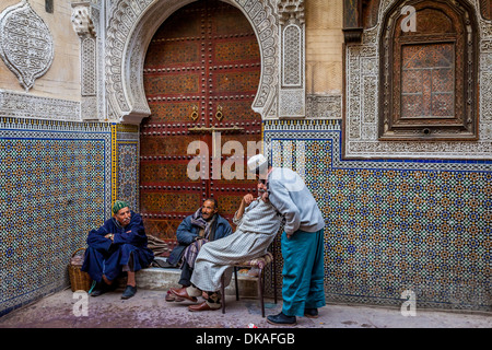 Men sitting outside Mosque Sidi Ahmed Tijani, The Medina, Fez, Morocco Stock Photo