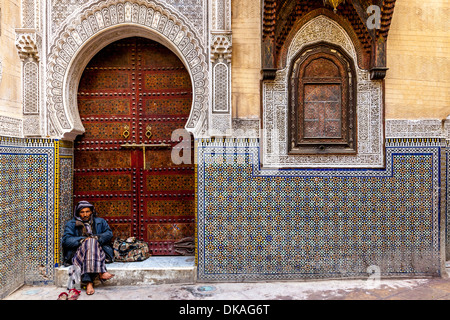 Man sitting outside Mosque Sidi Ahmed Tijani, The Medina, Fez, Morocco Stock Photo