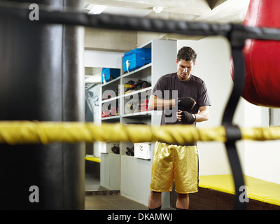 Boxer in changing room taping fists Stock Photo
