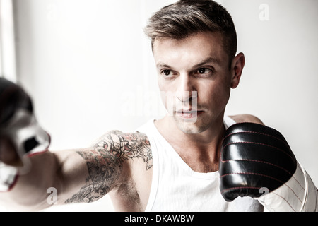 Studio shot of mid adult man boxing Stock Photo
